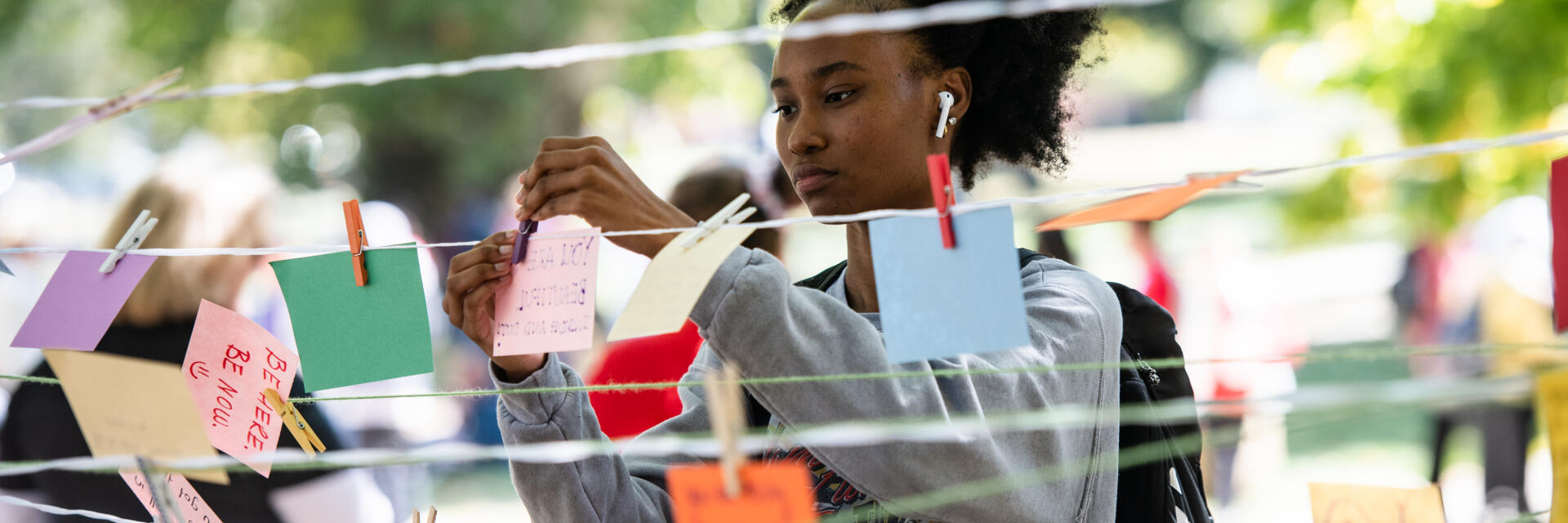 Student putting up post-it notes at an event